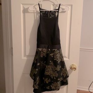 Black and gold mid-thigh dress, with lower back opening.